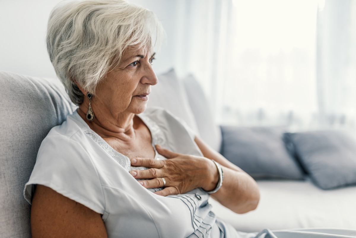 老妇患心脏病。 女人抱着她的胸部，剧烈的疼痛可能心脏病发作。 心脏病。 心脏问题的概念