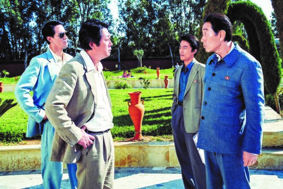 韩国电影《摩加迪沙》中饰演韩信盛大使的金伦奭 (左二)。该角色的真实人物的是韩国前驻索马里大使姜信盛。【图片来源：乐天娱乐】